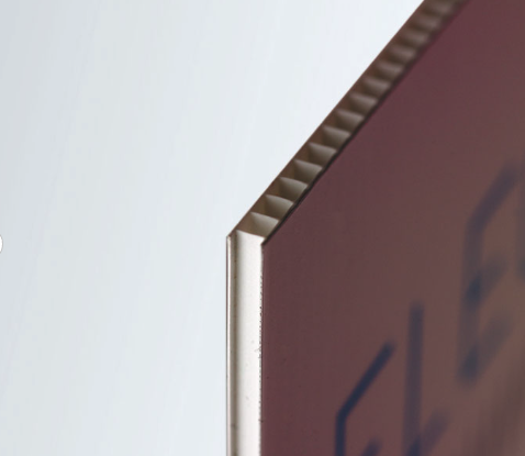 Detalle de cartel de polipropileno colocado en verja metálica